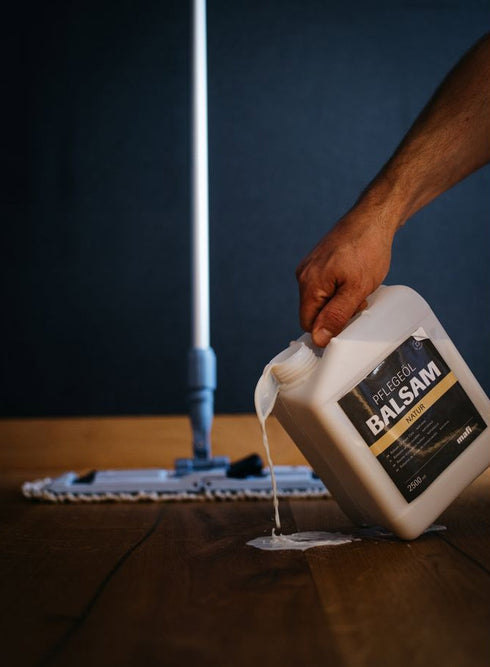 Photo of Mafi Balsam Oil being applied to wood floor for adding gloss shine and revitalize oil finish.